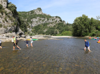 Passage de gué pour des randonneurs dans les Gorges de l'Ardèche